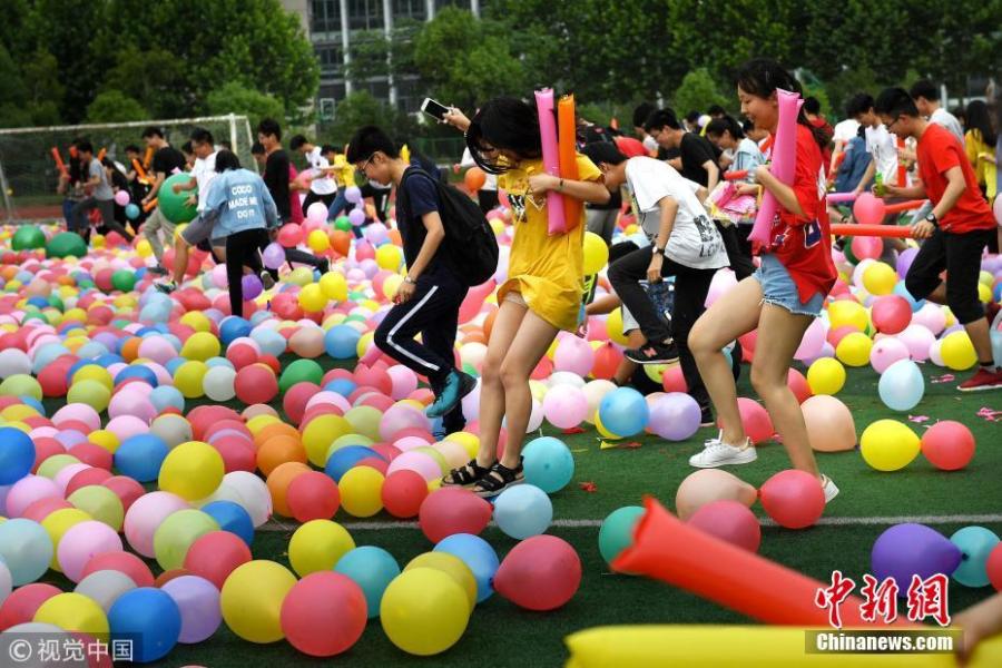Senior high school pupils trample balloons in an activity to relieve stress ahead of the National College Entrance Exams, or Gaokao, at No.1 High School in Hefei City, East China’s Anhui Province, May 28, 2018. The school prepared 20,000 balloons to allow some 2,000 students a fun break from the test stress. (Photo/VCG)