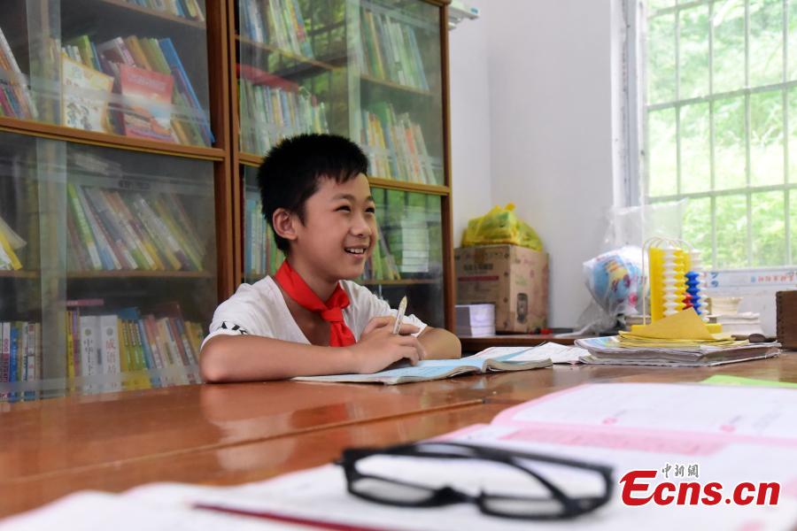 Li Jianwen, 10, learns with Pan Shanji, the only teacher at Dayadong Primary School in Liucheng County, South China’s Guangxi Zhuang Autonomous Region, May 31, 2018. It takes Li about one and a half hours to climb the mountain to his school, a three-hour return commute each day. (Photo: China News Service/Wang Yizhao)