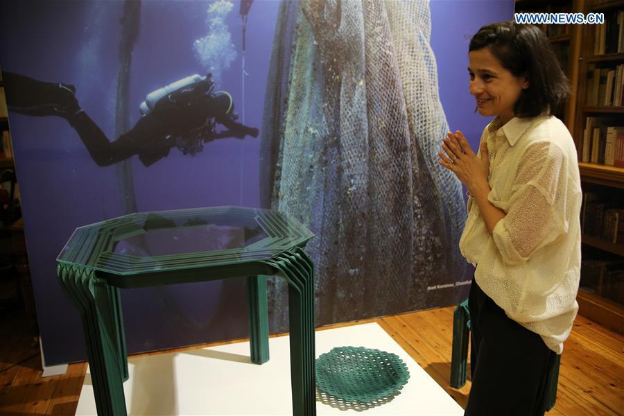 Fotini Setaki, Greek architect and founder of the design and research studio New Raw, stands next to a 3D-printed table during the exhibition \
