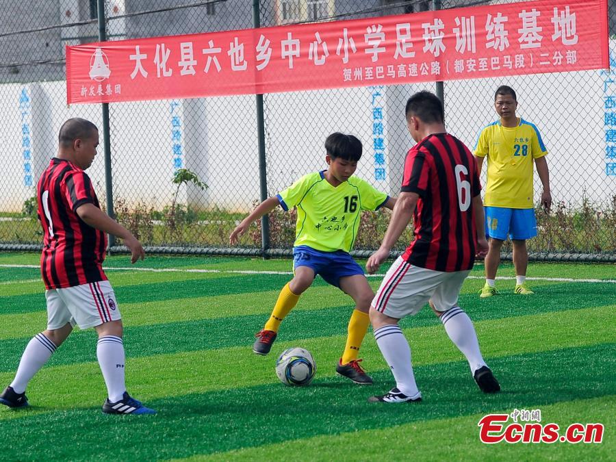 Wei Yuncheng (2ndL) plays in a football match in Liuye Township, Dahua Yao Autonomous County, South China’s Guangxi Zhuang Autonomous Region. Wei, a member of the Liuye Central Elementary School boys football team, said his dream is to one day leave his mountain home to explore the outside world by playing football well. The mountainous county, with a population of 400,000 people, is one the poorest in the region. (Photo: China News Service/Jiang Xuelin)