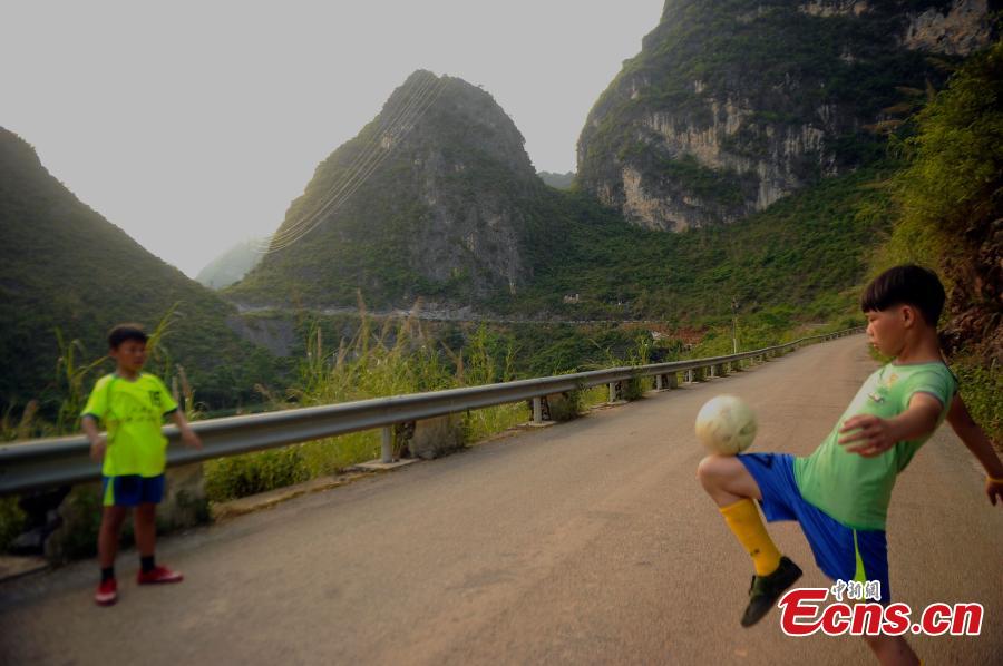 Wei Yuncheng plays football with Tang Qixing (R), whose father died and whose mother lives away for work. Tang also said his dream is to see the world beyond his high mountain home in Dahua Yao Autonomous County, South China’s Guangxi Zhuang Autonomous Region. (Photo: China News Service/Jiang Xuelin)