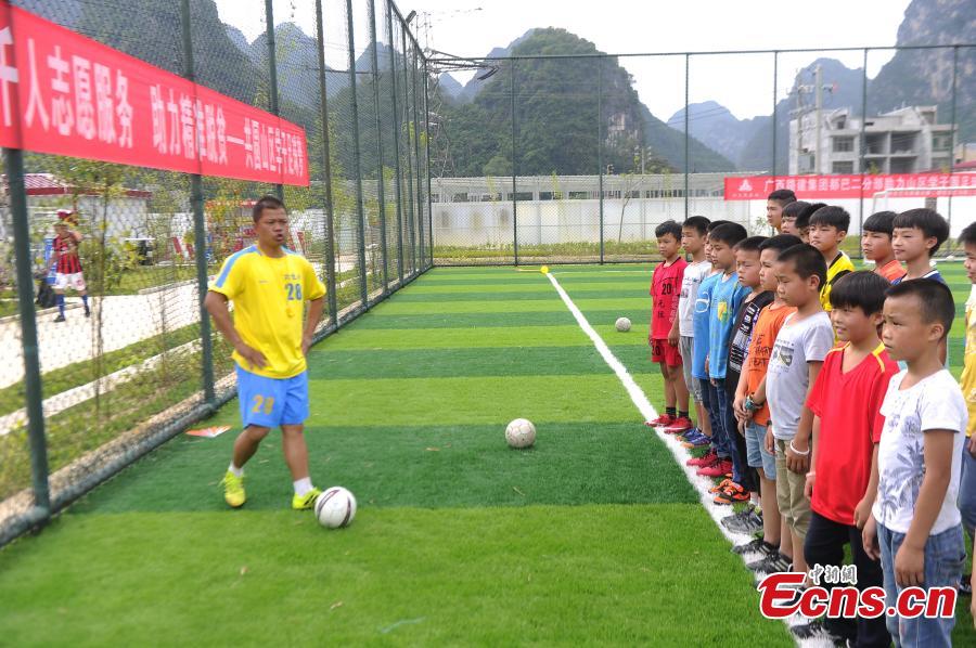 Lan Yushan, the coach of the Liuye Central Elementary School boys football team, has inspired children to develop an interest in football and dream big in Dahua Yao Autonomous County, South China’s Guangxi Zhuang Autonomous Region. (Photo: China News Service/Jiang Xuelin)