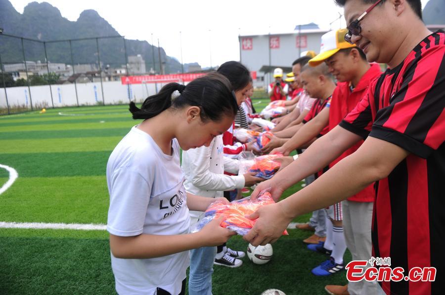 Volunteers from a road construction project donated football uniforms to Liuye Central Elementary School in Dahua Yao Autonomous County, South China’s Guangxi Zhuang Autonomous Region. (Photo: China News Service/Jiang Xuelin)