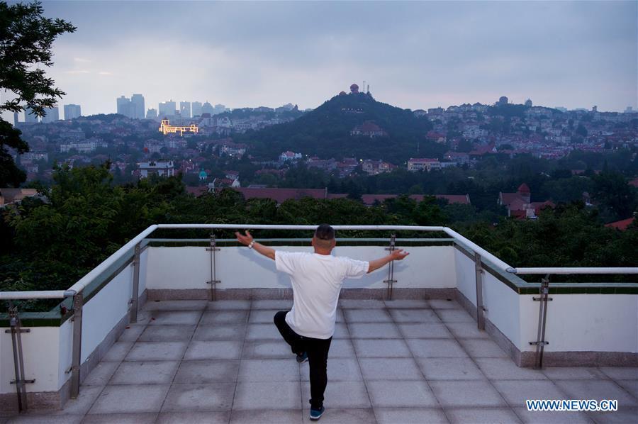 A man does exercises at a park in Qingdao, east China\'s Shandong Province, June 3, 2018. The 18th Shanghai Cooperation Organization (SCO) Summit is scheduled for June 9 to 10 in Qingdao. (Xinhua/Jiang Kehong)
