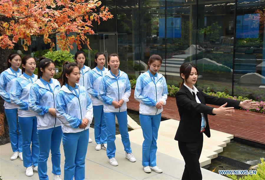 Etiquette teacher Lu Min (1st R) instructs volunteers for the 18th Shanghai Cooperation Organization (SCO) Summit in Qingdao, east China\'s Shandong Province, June 5, 2018. More than 20,000 volunteers have been mobilized to offer services for the summit, from assisting with guests\' arrival and departure, translation, and media requests, to the operation of city functions such as transportation, telecommunication, and banks. (Xinhua/Li Ziheng)