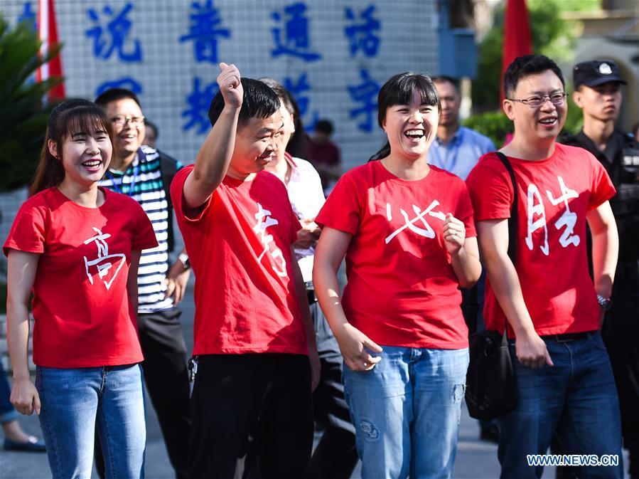 Teachers encourage examinees at an exam venue in Guiyang, capital of southwest China\'s Guizhou Province, June 7, 2018. About 9.75 million students have registered for the national college entrance examination, which takes place from June 7 to 8. (Xinhua/Tao Liang)
