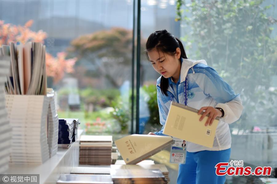 Volunteers work at the press center of the Shanghai Cooperation Organization Qingdao Summit in Qingdao City, East China’s Shandong Province, June 7, 2018. Some 370 volunteers from four universities in Qingdao are assisting journalists from home and abroad at the press center. (Photo/VCG)