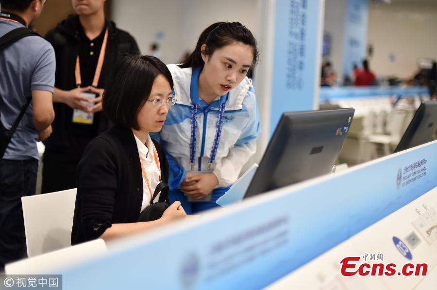 Volunteers work at the press center of the Shanghai Cooperation Organization Qingdao Summit in Qingdao City, East China’s Shandong Province, June 7, 2018. Some 370 volunteers from four universities in Qingdao are assisting journalists from home and abroad at the press center. (Photo/VCG)