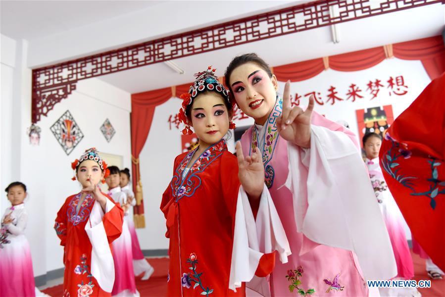 A teacher teaches students basic performing actions of Chinese drama at a primary school in Neiqiu County, north China\'s Hebei Province, June 8, 2018. The school introduced Chinese drama to student class to make it a way of inheriting traditional Chinese culture. (Xinhua/Zhu Xudong)