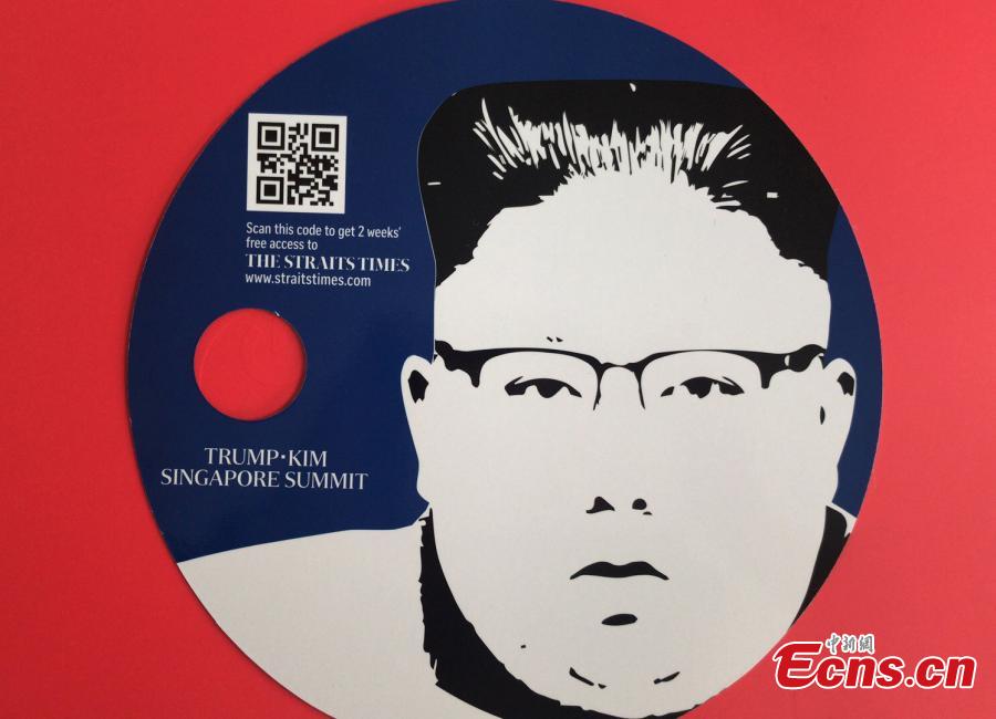 Souvenirs made for the DPRK-USA summit, including a notebook and a fan, are seen at the International Media Center at F1 Pit Building in Singapore, June 10, 2018. (Photo: China News Service/Meng Xiangjun)