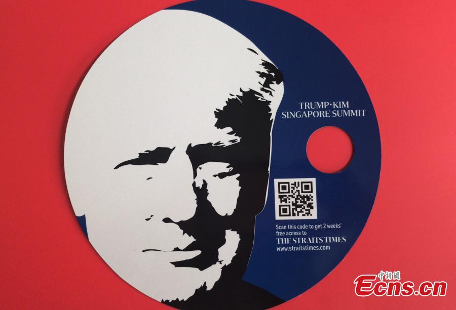 Souvenirs made for the DPRK-USA summit, including a notebook and a fan, are seen at the International Media Center at F1 Pit Building in Singapore, June 10, 2018. (Photo: China News Service/Meng Xiangjun)