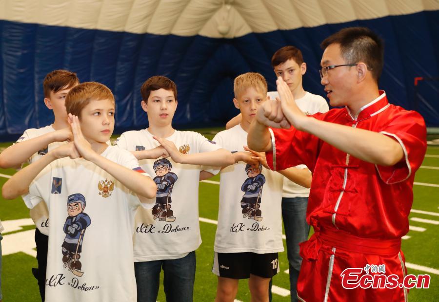Russian teenager ice hockey players learn about kung fu during a visit to Beijing Huijia Private School in Beijing, June 11, 2018. (Photo: China News Service/Liu Guanguan)
