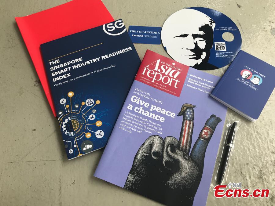 Souvenirs made for the DPRK-USA summit, including a notebook and a fan, are seen at the International Media Center at F1 Pit Building in Singapore, June 10, 2018. (Photo: China News Service/Meng Xiangjun)
