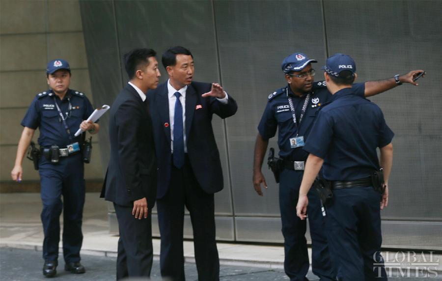 Related staffs coordinate security matters with the police outside the St. Regis hotel where DPRK leader Kim Jong-un has stayed in Singapore on Sunday. (Photo: Yang Sheng/GT)