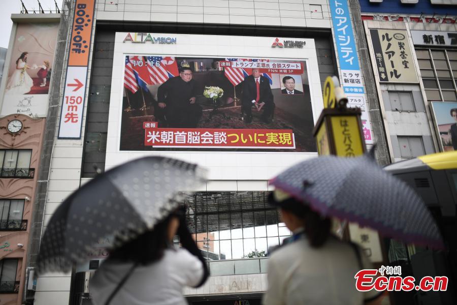 People watch a TV screen showing U.S. President Donald Trump meeting with the Democratic People\'s Republic of Korea (DPRK) leader Kim Jong Un in Singapore during a news program at a square in Tokyo, Japan, June 12, 2018. (Photo/Agencies)
