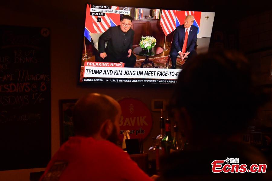 People watch a TV screen showing U.S. President Donald Trump meeting with the Democratic People\'s Republic of Korea (DPRK) leader Kim Jong Un in Singapore during a news program at a bar in Washington, the U.S., June 12, 2018. (Photo/Agencies)