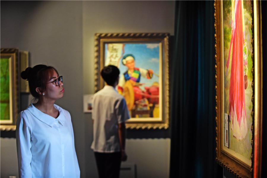 A woman examines an oil painting for sale at a border trade zone in Dandong, Liaoning province, which sells goods from the Democratic People\'s Republic of Korea. The zone\'s business has declined as a result of sanctions imposed on the DPRK by the UN last year. (YANG QING/XINHUA)
Sanctions bite
In August and September, the UN Security Council imposed two sets of sanctions on the DPRK, looking to exert economic pressure. The sanctions banned the export of coal, iron, lead and seafood, and also limited imports of crude oil and refined petroleum products. Moreover, they prohibited DPRK nationals from working overseas. The council has passed a number of similar resolutions since the DPRK conducted its first nuclear test in 2006.
As someone who specializes in providing machinery and services for the DPRK\'s mining sector, Zhou has been affected. \