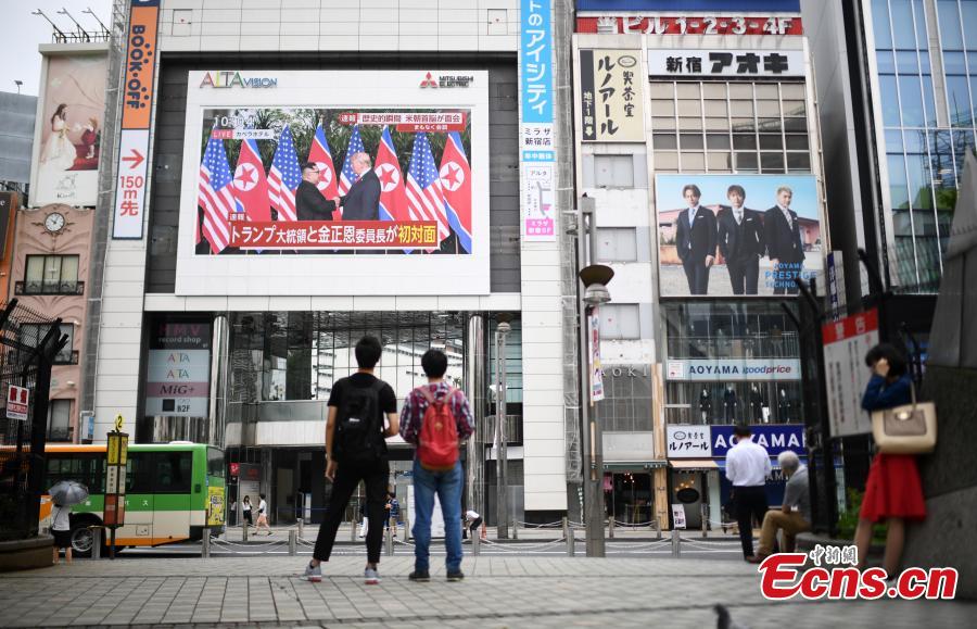 People watch a TV screen showing U.S. President Donald Trump meeting with the Democratic People\'s Republic of Korea (DPRK) leader Kim Jong Un in Singapore during a news program, at a square in Tokyo, Japan, June 12, 2018. (Photo/Agencies)