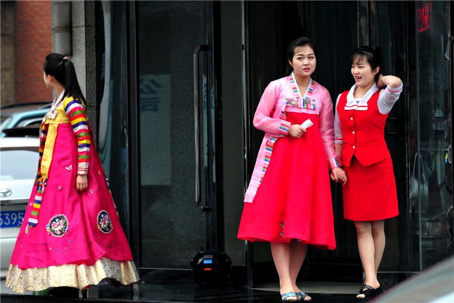 Restaurant waitresses dressed in Korean ethnic garb ready to welcome customers in Dandong, Liaoning province, on May 1. (YU HAIYANG/FOR CHINA DAILY)
Gaoli Street is one of the most popular places in Dandong for people from the two countries to meet and discuss business opportunities. On Zhou\'s desk, small Chinese and DPRK national desk flags flank a collection of books about Kim Il-sung, the DPRK\'s founder who was Kim Jongun\'s grandfather.
Printed in the DPRK, the books were presented to Zhou by his counterparts in the country. He has studied the volumes, which are written in Chinese, carefully to glean hints that would help him decode the mindset of the country\'s leaders.
Many people find the DPRK a mysterious place-but Zhou is not one of them. He travels to the country frequently and regards it as just another foreign destination with plenty of business potential.
\