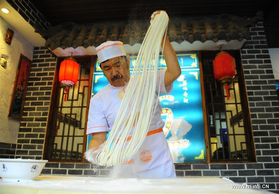 Quan Fujian pulls noodles at his restaurant in Yantai City, east China\'s Shandong Province, June 7, 2018. Fushan noodle is a traditional dish which is popular in Shandong Province. The noodle is hand pulled and cooked with various sauces and broths. The making of Fushan noodle was listed as a provincial intangible cultural heritage of Shandong in 2013. (Xinhua/Ren Pengfei)