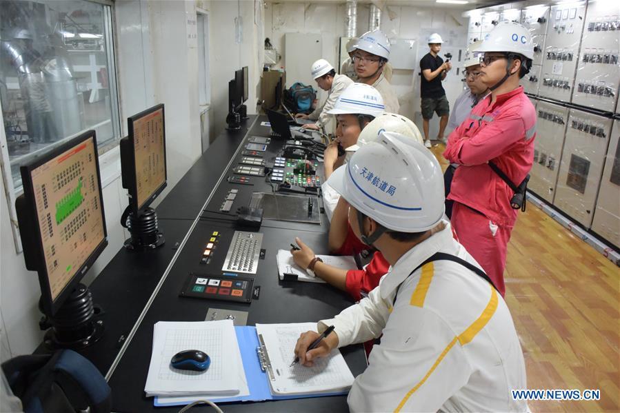 Staff members work at the control room on Tian Kun Hao, a Chinese-built dredging vessel, the largest of its kind in Asia, June 7, 2018. Tian Kun Hao, constructed by Tianjin Dredging Co. Ltd., a subsidiary of China Communication Construction Co., Ltd. (CCCC), finished its first sea trial. The 140-meter-long vessel, with the designed capacity to dredge 6,000 cubic meters per hour, can dig as deep as 35 meters under the sea floor. (Xinhua/Mao Zhenhua)