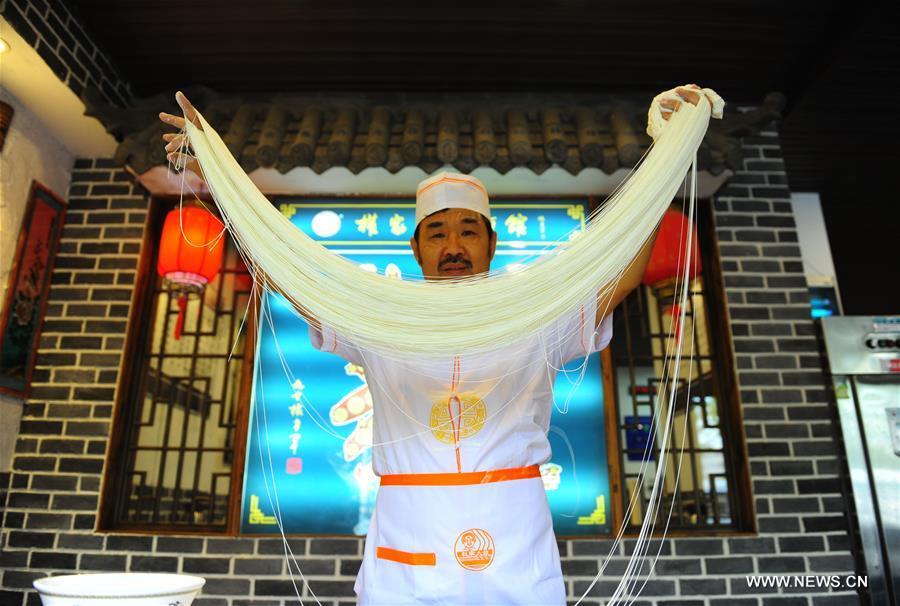 Quan Fujian pulls noodles at his restaurant in Yantai City, east China\'s Shandong Province, June 7, 2018. Fushan noodle is a traditional dish which is popular in Shandong Province. The noodle is hand pulled and cooked with various sauces and broths. The making of Fushan noodle was listed as a provincial intangible cultural heritage of Shandong in 2013. (Xinhua/Ren Pengfei)