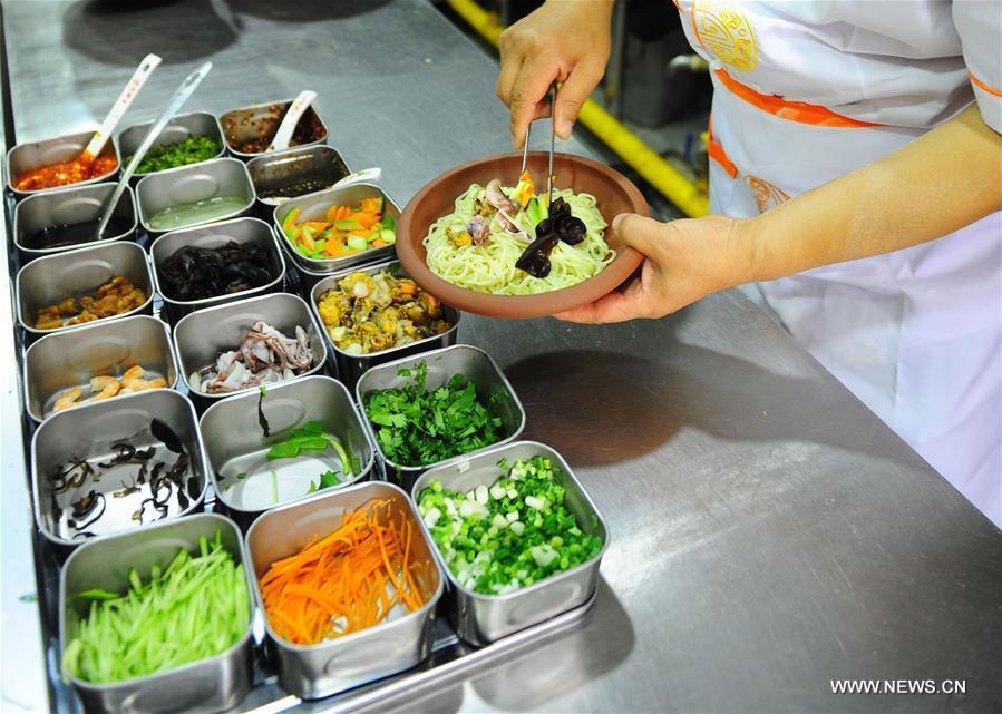 Quan Fujian prepares meals for customers at his restaurant in Yantai City, east China\'s Shandong Province, June 7, 2018. Fushan noodle is a traditional dish which is popular in Shandong Province. The noodle is hand pulled and cooked with various sauces and broths. The making of Fushan noodle was listed as a provincial intangible cultural heritage of Shandong in 2013. (Xinhua/Ren Pengfei)