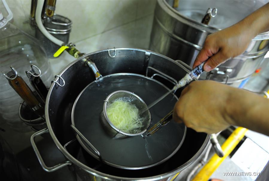 Quan Fujian prepares meals for customers at his restaurant in Yantai City, east China\'s Shandong Province, June 7, 2018. Fushan noodle is a traditional dish which is popular in Shandong Province. The noodle is hand pulled and cooked with various sauces and broths. The making of Fushan noodle was listed as a provincial intangible cultural heritage of Shandong in 2013. (Xinhua/Ren Pengfei)
