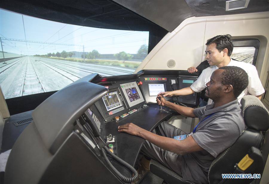 A railway executive from Kenya experiences a simulation of high-speed train driving at a training base for high-speed railway staff in Wuhan, central China\'s Hubei Province, June 12, 2018. Altogether 63 railway executives from 13 countries including Thailand, Sri Lanka and Laos visited the training base Tuesday. (Xinhua/Xiao Yijiu)