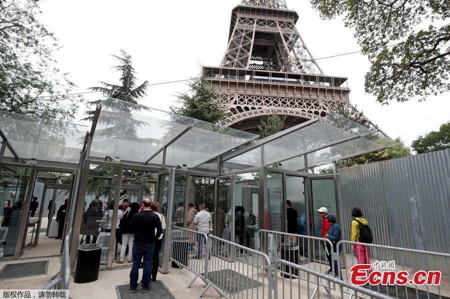 Tourists and visitors queue to pass the security check at the entrance to the new glass fence around the Eiffel Tower in Paris, France, June 14, 2018. Paris authorities are building a permanent security belt around the Eiffel Tower, replacing the current fencing around it with more visually appealing glass walls. (Photo/Agencies)