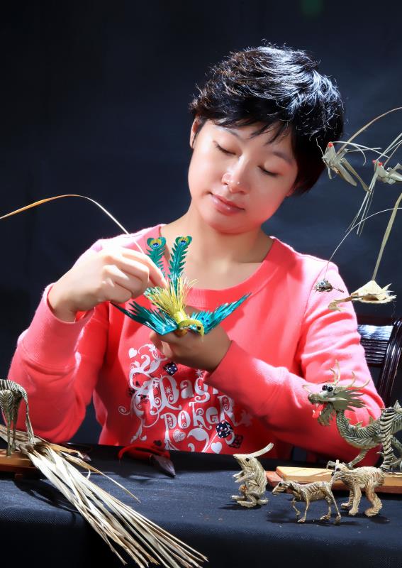 Artist Zhou Jialin works on a bird. (Photo by Song Guoqing/China Daily)