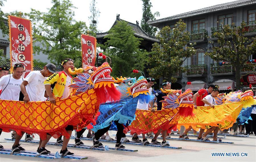Visitors experience an on-land dragon boat race in Zaozhuang City, east China\'s Shandong Province, June 17, 2018. People enjoy their holiday time during the Dragon Boat Festival. (Xinhua/Sun Zhongzhe)