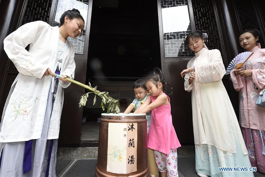 Children experience traditional customs at the Museum of Hangzhou Local Chronicles in Hangzhou, capital of east China\'s Zhejiang Province, June 17, 2018. People enjoy their holiday time during the Dragon Boat Festival. (Xinhua/Li Zhong)