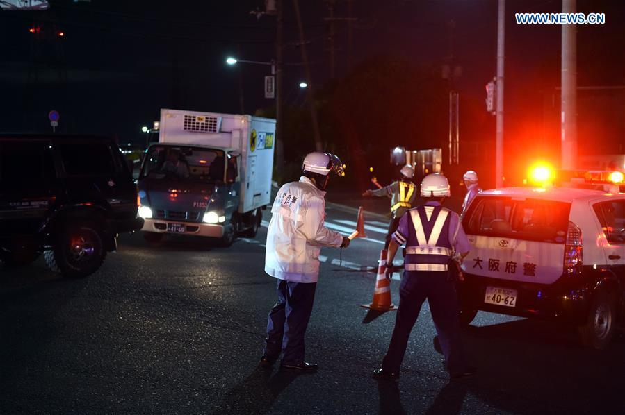 Policemen lead vehicles away at a site of a damaged road in Osaka, Japan, on June 18, 2018. At least three people have been confirmed dead and more than 90 others injured as a result of a 6.1 magnitude earthquake striking Osaka prefecture in western Japan on Monday morning. (Xinhua/Ma Ping)