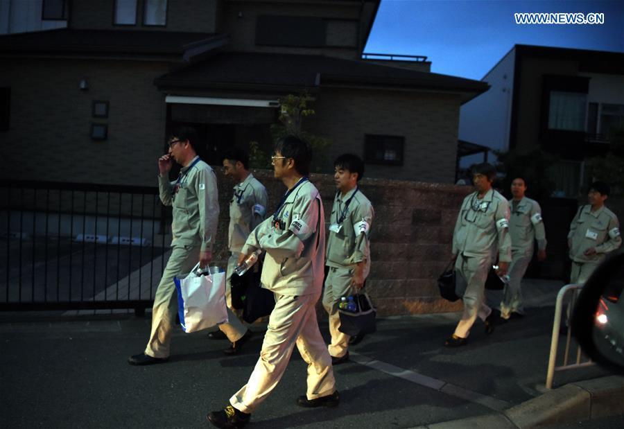 Engineers walk at a street in Takatsuki, Osaka, Japan, on June 18, 2018. At least three people have been confirmed dead and more than 90 others injured as a result of a 6.1 magnitude earthquake striking Osaka prefecture in western Japan on Monday morning. (Xinhua/Ma Ping)