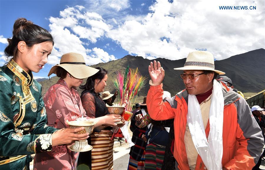 Villagers who have moved from Nyima County of Nagqu during a relocation program with environmental purposes are welcomed at their new settlement in Lhasa, southwest China\'s Tibet Autonomous Region, June 18, 2018. A total of 1,102 residents have been relocated to a new settlement in Lhasa to make their old neighbourhoods accessible to wild animals in the Qiangtang National Nature Reserve. Completed on Monday, the relocation marked the first such program carried out for the sake of environmental protection in areas at high altitudes in Tibet Autonomous Region. (Xinhua/Chogo)