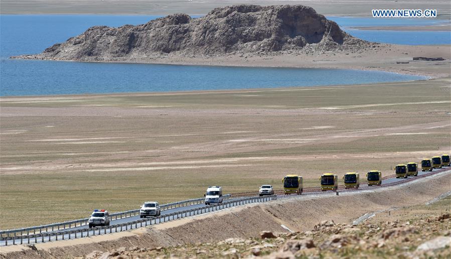 A motorcade of coaches carry villagers from Nyima County of Nagqu to a new settlement in Lhasa during a relocation program with environmental purposes in southwest China\'s Tibet Autonomous Region, June 17, 2018. A total of 1,102 residents have been relocated to a new settlement in Lhasa to make their old neighbourhoods accessible to wild animals in the Qiangtang National Nature Reserve. Completed on Monday, the relocation marked the first such program carried out for the sake of environmental protection in areas at high altitudes in Tibet Autonomous Region. (Xinhua/Chogo)