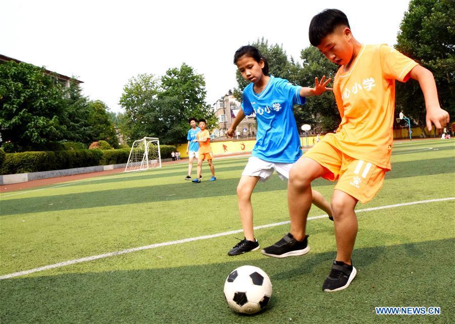 Children compete in a football match at Yuanqu Central Primary School in Yuanqu County, north China\'s Shanxi Province, June 19, 2018. Children enjoyed the fun of playing football as the 2018 FIFA World Cup goes on in Russia. (Xinhua/Cui Songliang)