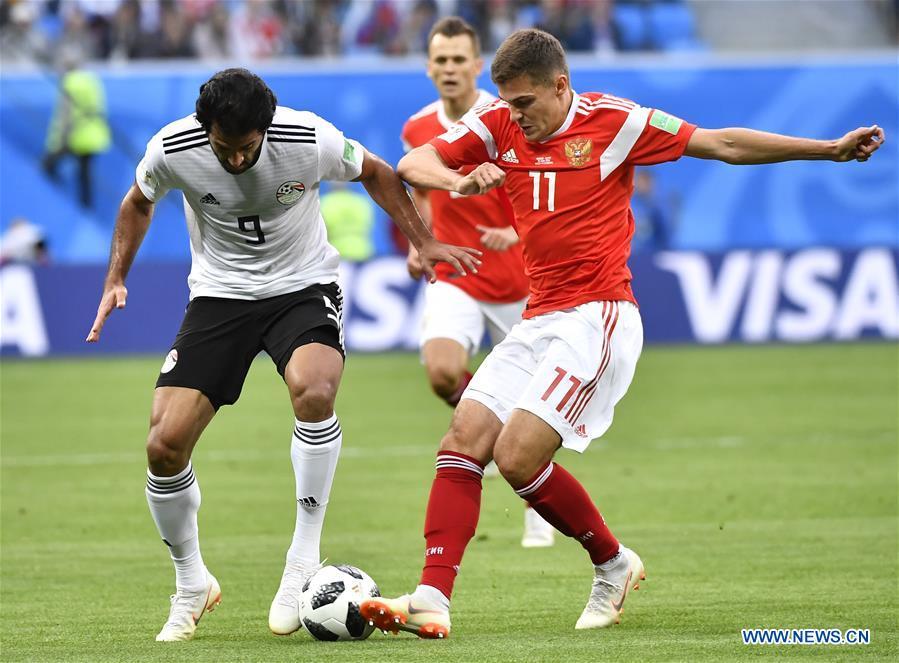 Marwan Mohsen (L) of Egypt vies with Roman Zobnin of Russia during a Group A match between Russia and Egypt at the 2018 FIFA World Cup in Saint Petersburg, Russia, June 19, 2018. (Xinhua/Chen Yichen)
