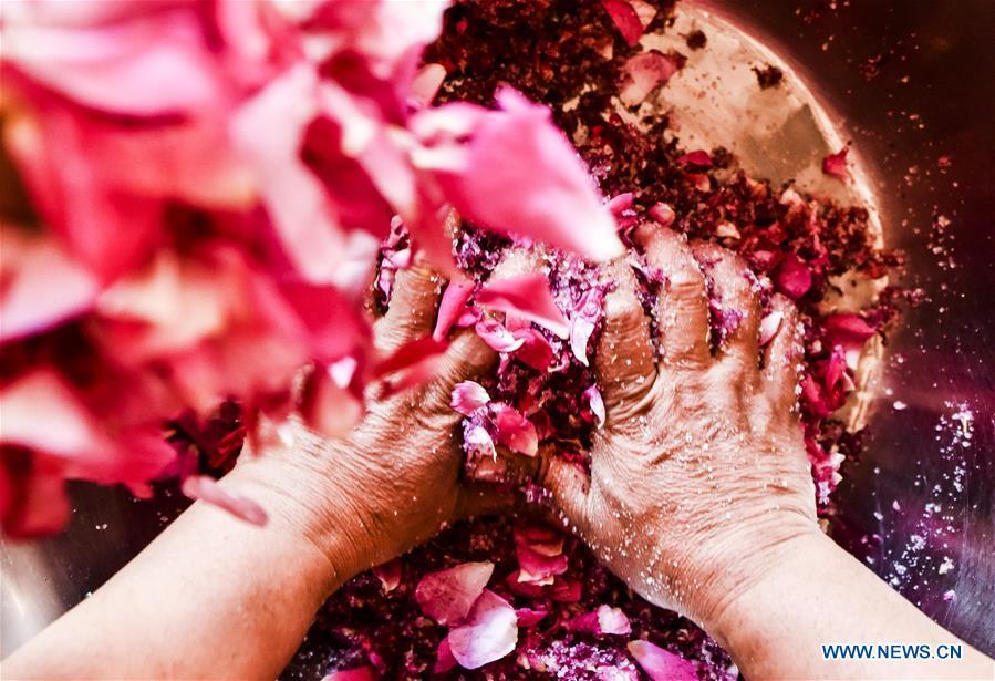 Flower grower Tajinisa makes rose sauce at a village in Hotan, northwest China\'s Xinjiang Uygur Autonomous Region, June 6, 2018. People in the village are good at making rose sauce, and that is an important source of income for them. (Xinhua/Zhao Ge)