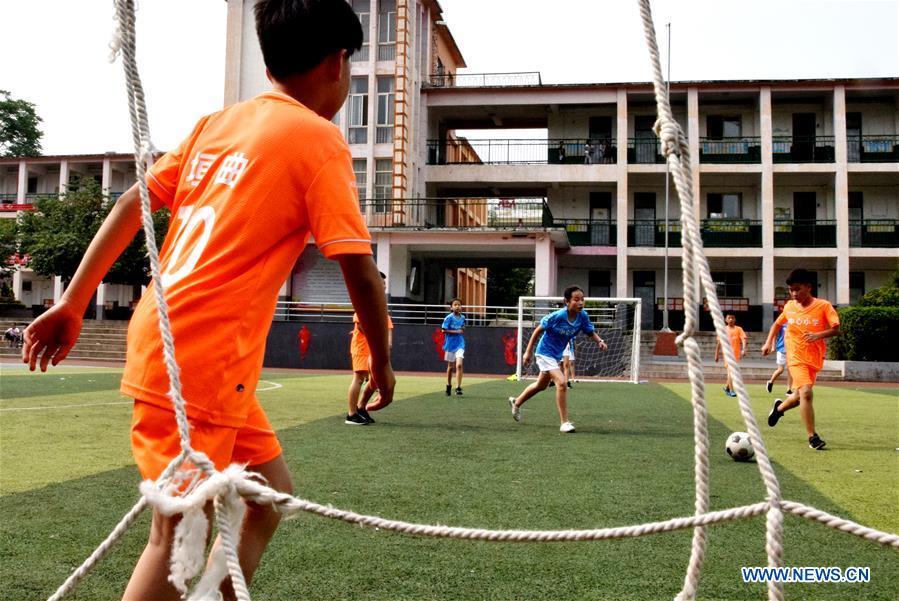 Children compete in a football match at Yuanqu Central Primary School in Yuanqu County, north China\'s Shanxi Province, June 19, 2018. Children enjoyed the fun of playing football as the 2018 FIFA World Cup goes on in Russia. (Xinhua/Cui Songliang)