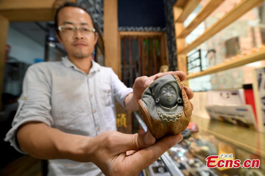Jade carving craftsman Qian Siyu works in his studio in Nanning City, South China’s Guangxi Zhuang Autonomous Region, June 20, 2018. Qian, born in 1984, is known for combining the elements of the culture and traditions of the Zhuang ethnic group into his designs. (Photo: China News Service/Yu Jing)