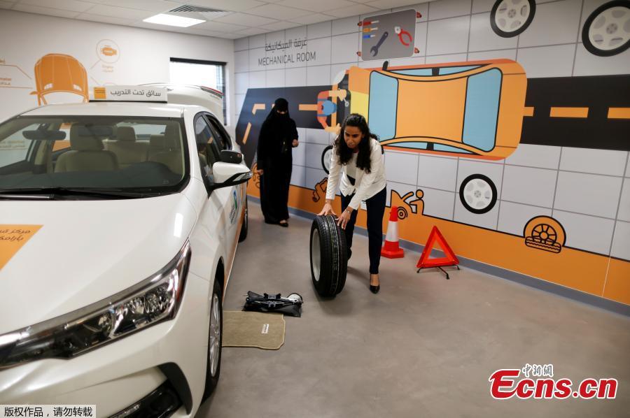 Trainee Maria al-Faraj practices how to adjust a tire during a driving lesson at Saudi Aramco Driving Center in Dhahran, Saudi Arabia, June 6, 2018. (Photo/Agencies)