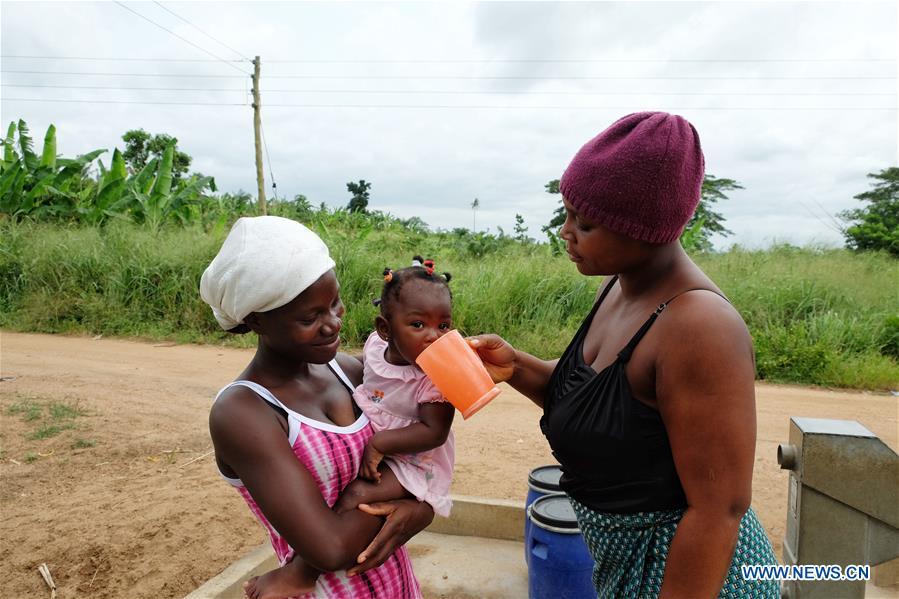 A woman gives water to a baby near a borehole in Agyakwa Village, Eastern Region, Ghana, on June 18, 2018. The government of China is providing 1,000 boreholes for hundreds of rural communities in six out of the ten regions of Ghana to bring clean water to the people. (Xinhua/Zhao Shuting)