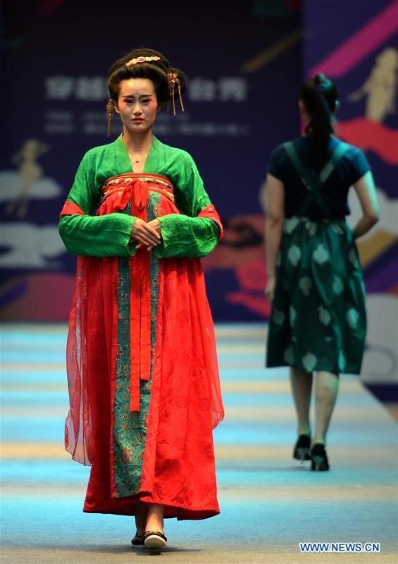 Models present creations during a fashion show in Xi\'an, capital of northwest China\'s Shaanxi Province, June 19, 2018. Both modern creations and traditional costumes of the Tang Dynasty (618-907) were presented in the show. (Xinhua/Liu Xiao)