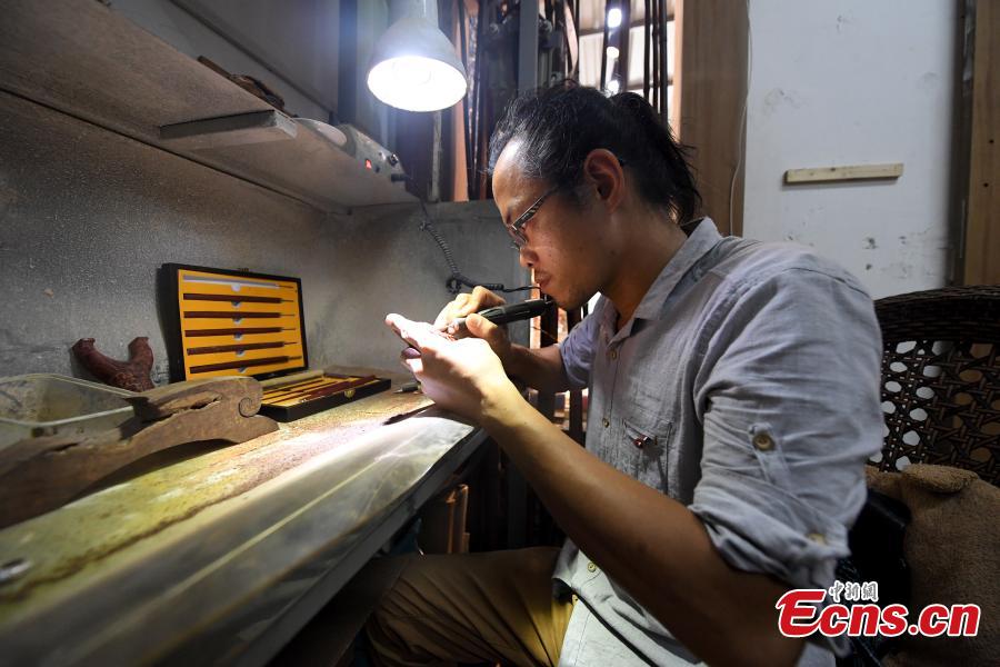 Jade carving craftsman Qian Siyu works in his studio in Nanning City, South China’s Guangxi Zhuang Autonomous Region, June 20, 2018. Qian, born in 1984, is known for combining the elements of the culture and traditions of the Zhuang ethnic group into his designs. (Photo: China News Service/Yu Jing)