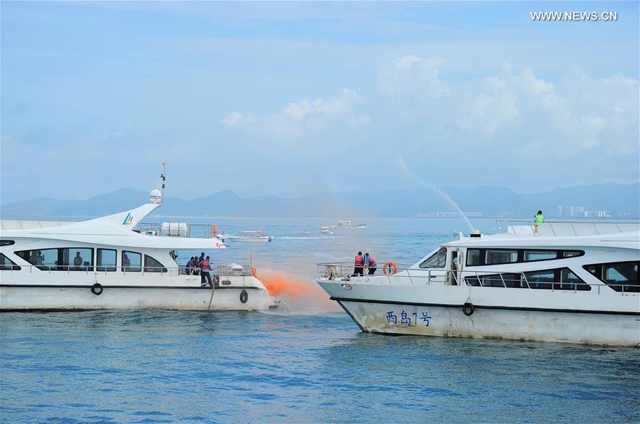 Rescuers participate in an emergency drill on securing marine transportation in Sanya, south China\'s Hainan Province, June 22, 2018. (Xinhua/Sha Xiaofeng)