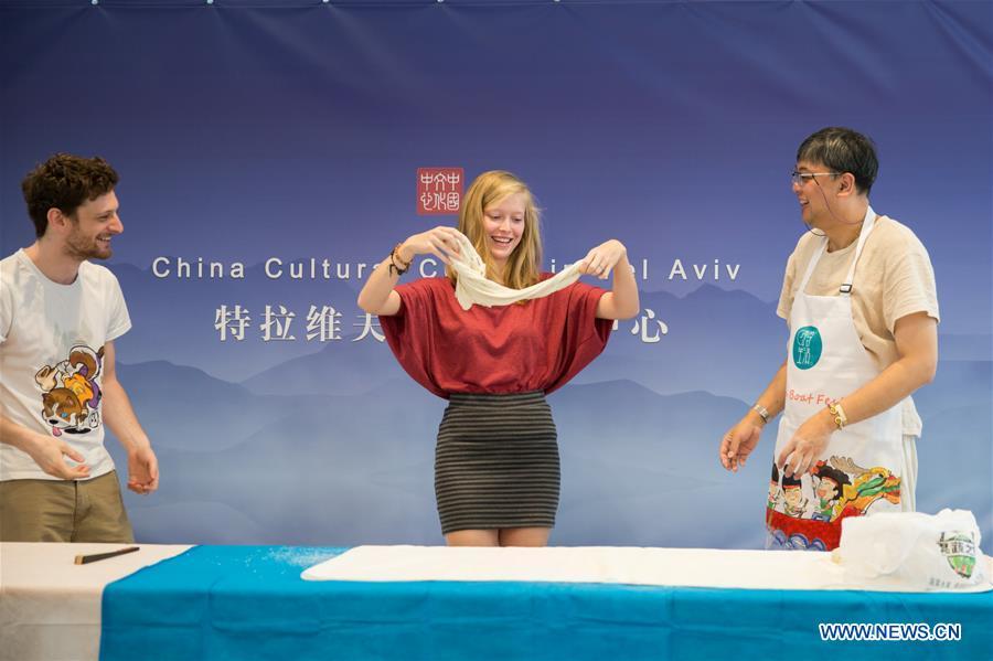An Israeli girl (C) learns noodle making skills during a Chinese food festival event at the Chinese Cultural Center in Tel Aviv, Israel, on June 22, 2018. (Xinhua/Guo Yu)