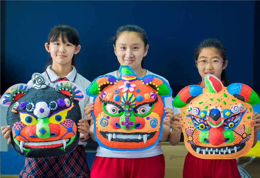 Students show their auspicious beast masks at the Nanchafang Primary School in Hohhot, Inner Mongolia autonomous region, on June 27, 2018. (Photo/Asianewsphoto)