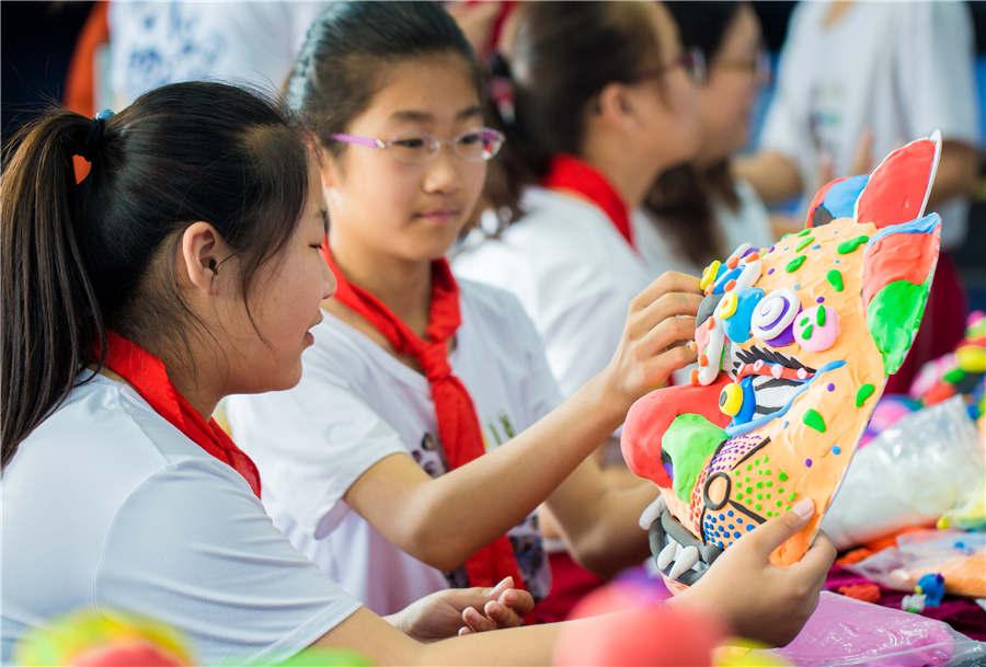 Students make auspicious beast masks at the Nanchafang Primary School in Hohhot, Inner Mongolia autonomous region, on June 27, 2018. (Photo/Asianewsphoto)